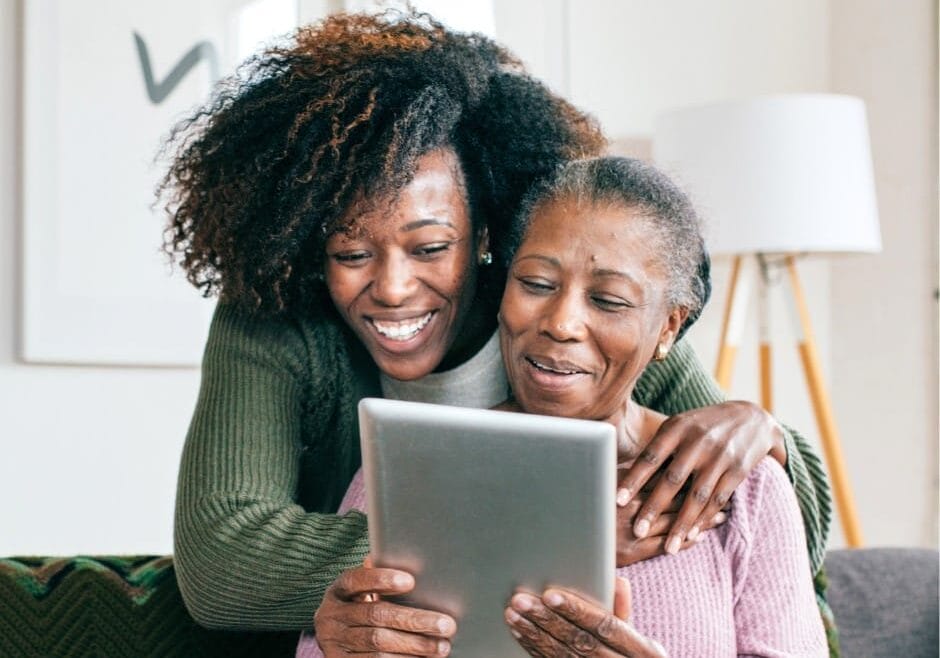 Mother and daughter look at computer togethor.