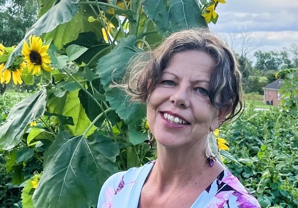 Sally Iseral in front of sunflowers